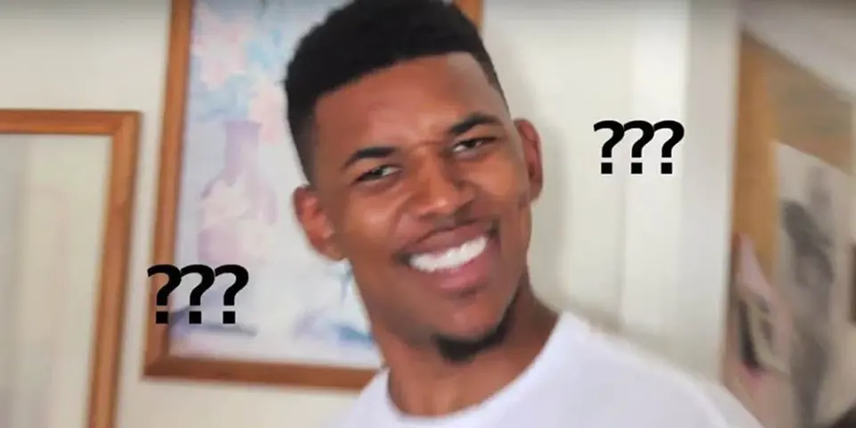 Grinning man in a white T-shirt turning to camera with a baffled squint, black "???" marks floating on either side
