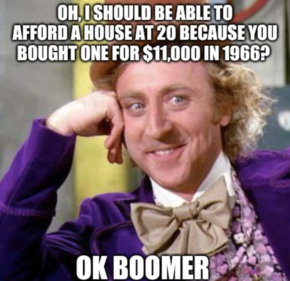 Curly-haired man in a purple velvet coat and bow tie smirking with chin on hand, captioned "OK BOOMER"