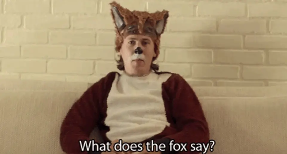 A man in a fox costume on a couch under the subtitle "What does the fox say?"