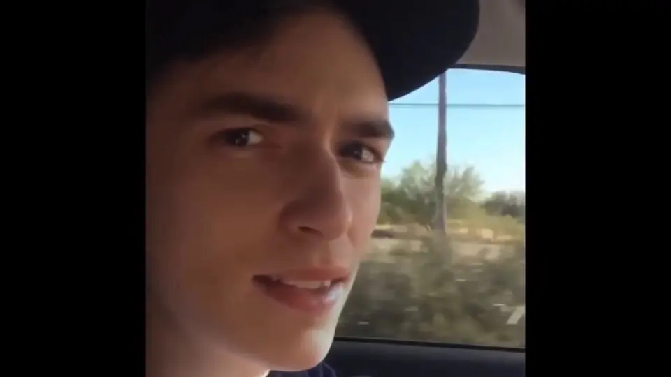 Young man in a cap filming himself inside a car for the "road work ahead" Vine