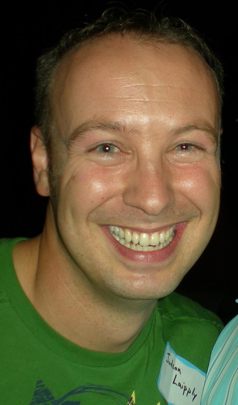 Candid close-up of a smiling man wearing a "Judson Laipply" name tag