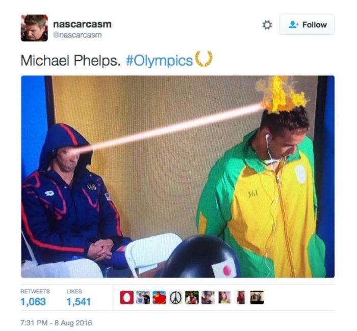 Tweet screenshot captioned "Michael Phelps. #Olympics" showing a hooded athlete firing a laser beam at a rival's flaming hair
