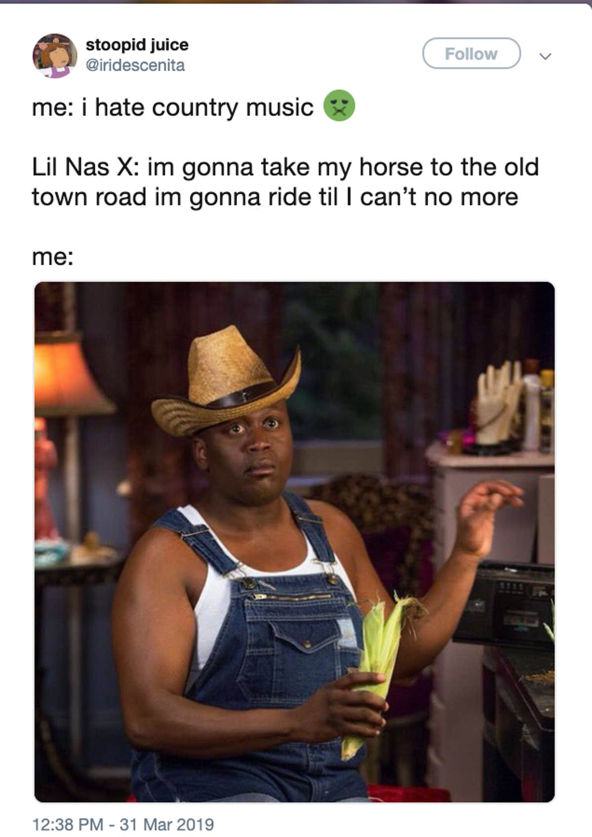 Screenshot of a tweet joking about hating country music, with a photo of a man in cowboy hat and overalls holding corn